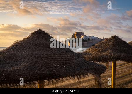 Landschaft der Altstadt von Peniscola zwischen den Sonnenschirmen bei Sonnenaufgang, Peñíscola, Castellon, Spanien Stockfoto