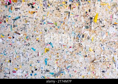 Eine alte Community-Pinnwand, bedeckt mit den zerrissenen bunten Fetzen alter Flyer und Werbung. Ein abstraktes Detail einer Pinnwand für Stockfoto