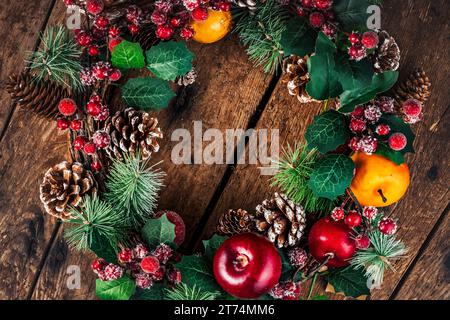 Weihnachtskranz auf rustikalem hölzernem Hintergrund. Weihnachtsdekoration mit Kopierraum für Text Stockfoto