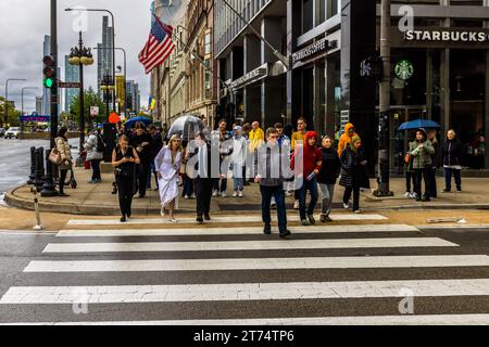 Braut und Bräutigam bei schlechtem Wetter auf der Michigan Avenue, Chicago. Braut und Bräutigam im Regen an einer geschäftigen Kreuzung in Chicago, USA Stockfoto