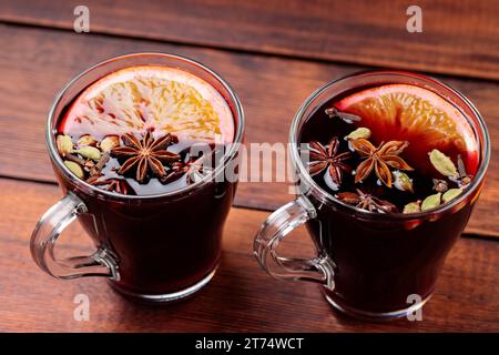 Glühwein Heißgetränk mit Zitrusfrüchten und Gewürzen mit Zutaten auf Holztafeln. Nahaufnahme Stockfoto