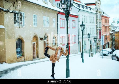 Mädchen macht Spaß auf einer verschneiten europäischen Straße Stockfoto