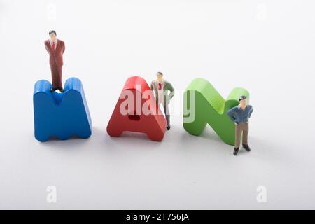 Kleine Männerfigur neben bunten Holzbriefen sagt MANN Stockfoto