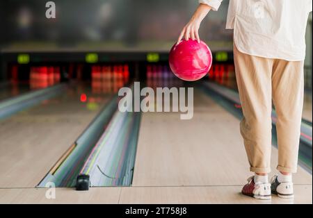 Person, die eine Bowlingkugel hält Stockfoto