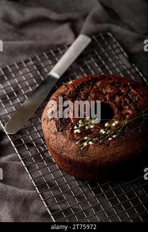 Schokoladenkuchen grauer Hintergrund mit Messer Stockfoto