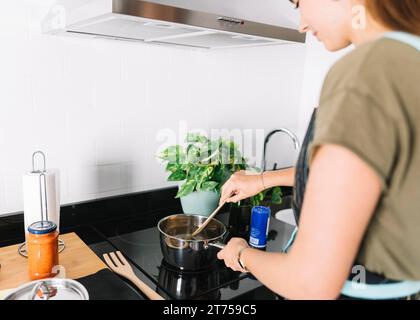 Nahaufnahme einer Frau, die Wasser-Soße-Pfanne kocht Stockfoto