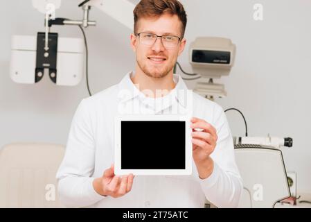 Portrait-Augenoptiker, der Tablettenschablone präsentiert Stockfoto