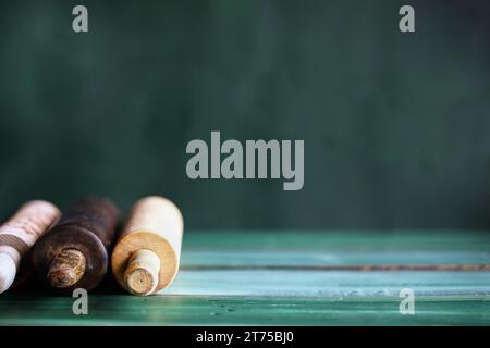 Zusammenfassung von drei Rollnadeln auf einem grünen rustikalen Tisch. Selektiver Fokus mit verschwommenem Vorder- und Hintergrund. Kopierbereich. Stockfoto