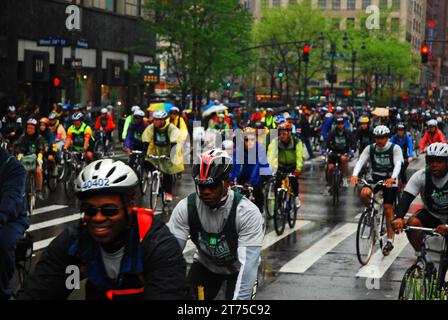 Eine große Gruppe von Fahrradfahrern geht während der New York Five Borough Bike Tour im Regen durch die Straßen von Manhattan Stockfoto