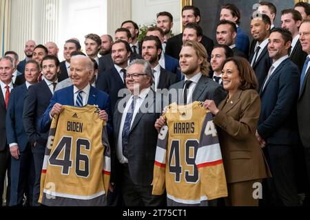 Washington, Usa. November 2023. US-Präsident Joe Biden, links, und Vizepräsidentin Kamala Harris, rechts, posieren mit Eishockeytrikots, die während einer Veranstaltung anlässlich des Stanley Cup-Sieges der Vegas Golden Knights 2023 im State Dining Room des Weißen Hauses, 13. November 2023 in Washington, DC, präsentiert wurden. Adam Schultz/White House Photo/Alamy Live News Stockfoto