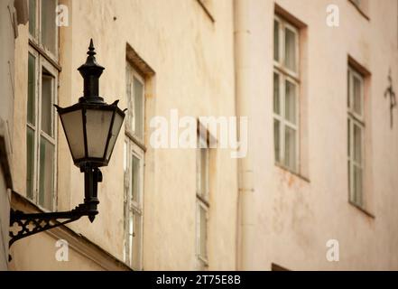 Eine alte dunkle Straßenlaterne mit Glaseinsätzen hängt an der Wand eines Hauses in Tallinn. Hochwertige Fotos Stockfoto