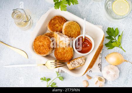 Backform mit leckeren Fleischkoteletts mit Soße auf weißem Hintergrund Stockfoto