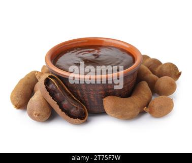 Schüssel mit leckerer Tamarindenmarmelade und Früchten auf weißem Hintergrund Stockfoto