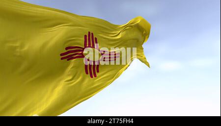 Nahaufnahme der Flagge des Bundesstaates New Mexico, die im Wind winkt. Symbol der roten Sonne Zia auf einem gelben Feld. 3D-Darstellung. Gewelltes Material Stockfoto