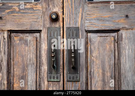 Dekorative Griffe an abgenutzten Holzkirchentüren Stockfoto
