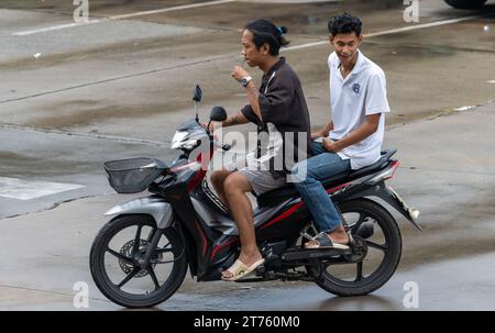 SAMUT PRAKAN, THAILAND, 13. Oktober 2023, zwei Männer fahren im Regen mit einem Motorrad Stockfoto