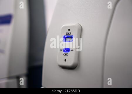 USB-Ladeanschluss für elektronische Geräte am Flugzeugsitz Stockfoto