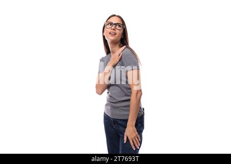 Junge Promoterin mit Brille in einem grauen T-Shirt in einem Identitätsmuster auf weißem Hintergrund mit Kopierraum Stockfoto