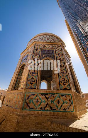 Historischer Friedhof von Shahi Zinda mit seinen fein dekorierten Mausoleen durch einen Bogen in Samarkand, Usbekistan. Stockfoto