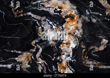 Großformatige Textur, schwarzer Marmor mit welligen Cremeadern und braunen Flecken. Stockfoto