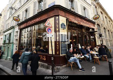 Die lebhafte Bar und das Restaurant Le Progrès an der Ecke Rue des Trois Frères Rue Yvonne le Tac in Montmartre, Paris, Frankreich. Stockfoto