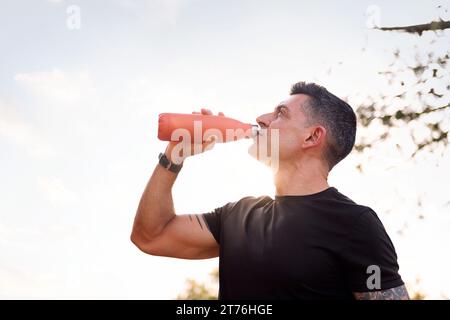 Ein Mann trinkt Wasser während ihres Trainings Stockfoto