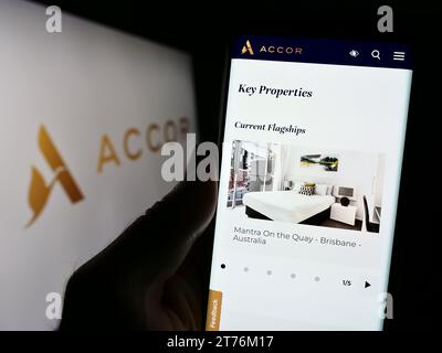 Person, die ein Handy hält, mit der Webseite des französischen Hotelunternehmens Accor SA vor dem Logo. Konzentrieren Sie sich auf die Mitte des Telefondisplays. Stockfoto
