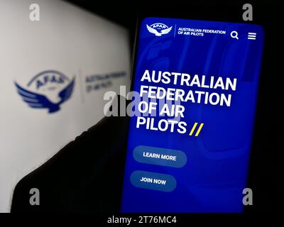 Person mit Smartphone und Webseite des Verbands Australian Federation of Air Pilots (AFAP) mit Logo. Konzentrieren Sie sich auf die Mitte des Telefondisplays. Stockfoto