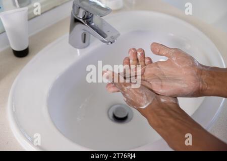 Nahaufnahme eines rassistischen Mannes, der zu Hause im Badezimmer die Hände wäscht Stockfoto