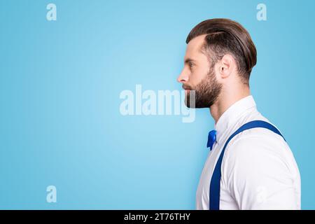 Profilseitenansicht Porträt mit Werbeträger, leerer Platz für Werbung des berühmten konzentrierten Sängers, der Schleife, Hemd, Hosenträger trägt, isoliert auf Stockfoto