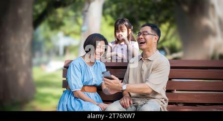 Großeltern spielt mit einer Enkelin im Park am Morgen. Familie, Liebe und Enkel, die sich mit Großvater und Großmutter verbinden Stockfoto