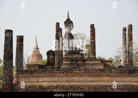 Mann betet auf den Knien vor Buddha Stockfoto