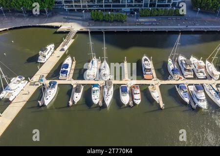 Blick aus der Vogelperspektive auf Luxusyachten, die auf einem trüben Fluss in den Docklands in Melbourne, Victoria, Australien, liegen. Stockfoto