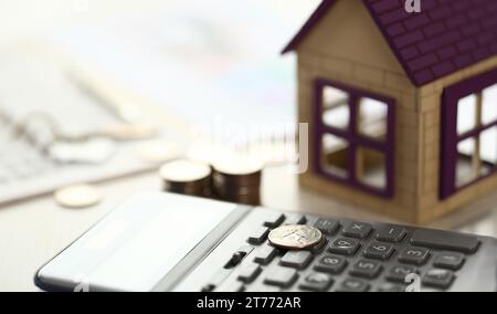 Münze lag auf Rechner, Haus Modell auf Büro Schreibtisch Stockfoto