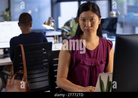 Porträt einer asiatischen Geschäftsfrau, die am Schreibtisch sitzt und im Büro einen Laptop benutzt, Kopierraum Stockfoto