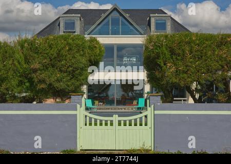 Strandanlage am Strand von East Preston in der Nähe von Littlehampton in West Sussex, England. Blick vom Strand mit Mauer, Hecke und Tor Stockfoto