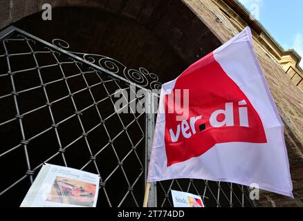 Jena, Deutschland. November 2023. Eine Verdi-Fahne fliegt vor der Kundgebung der Mitarbeiter des öffentlichen Dienstes im historischen Rathaus. Die gewerkschaft Verdi hat im Rahmen der Tarifverhandlungen im öffentlichen Sektor der bundesländer zu einem ganztägigen Warnstreik in ganz Deutschland aufgerufen. Unter anderem werden das Universitätsspital Jena, die Universität Jena, die Fachhochschule Ernst Abbe Jena und das Studierendenwerk Thüringen streiken. Quelle: Martin Schutt/dpa/Alamy Live News Stockfoto