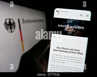 Handybesitzer mit Webseite des Bundesnachrichtendienstes (BND) mit Logo. Konzentrieren Sie sich auf die Mitte des Telefondisplays. Stockfoto