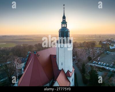 Dieser Blick aus der Vogelperspektive fängt die malerische Winterszene einer Kirche ein, die von ihrem idyllischen schneebedeckten Gelände umgeben ist Stockfoto