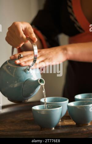 Nahaufnahme einer Frau Hände Gießen grüner Tee Stockfoto