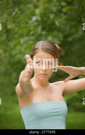 Eine junge Frau, die Tai Chi macht Stockfoto