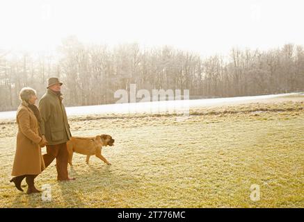 Profil von ein älteres Paar, Wandern mit Hund in einem park Stockfoto