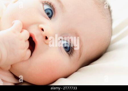 Babymädchen mit der Hand in den Mund, Nahaufnahme Stockfoto