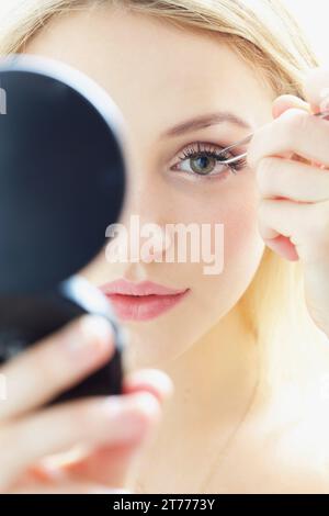 Close up Portrait of Young Woman Anwendung falsche Wimpern Stockfoto