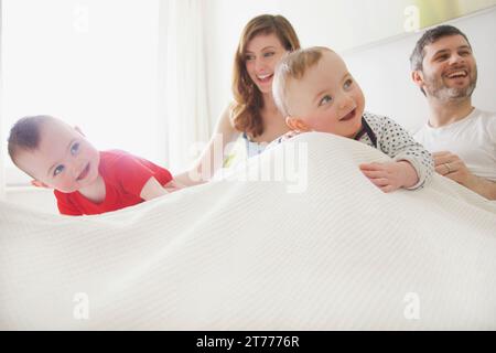Paar im Bett mit Baby Zwillinge Stockfoto