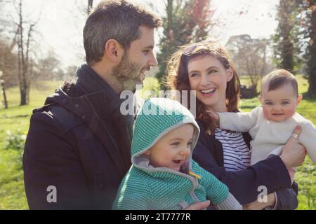 Familie im Park hält Baby Zwillinge Stockfoto