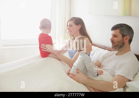 Paar im Bett mit Baby Zwillinge Stockfoto