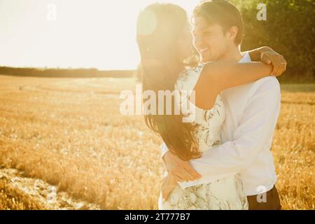 Lächeln, paar umarmt in einem Feld Stockfoto