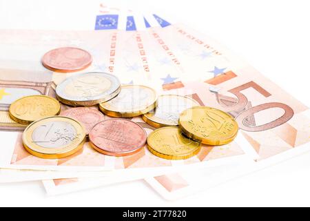 Detail einiger Euro-Münzen und -Banknoten auf weißem Hintergrund Stockfoto