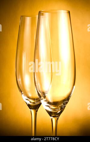 Zwei leere Gläser Champagner vor goldenem Hintergrund Stockfoto